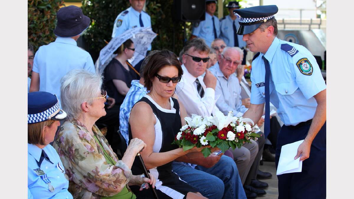 June Howe and her daughter Kim Howe are presented with a floral wreath by Mulwala police officer Sgt Grant Churchin. 
