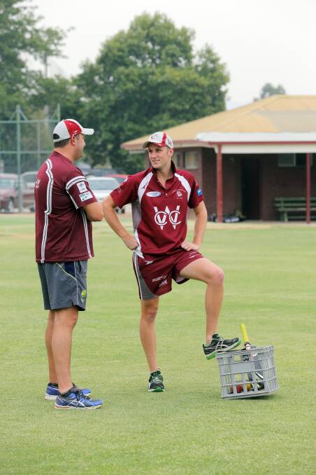 Brendan Klein-Boonschate talks to fellow injured player Leigh Collins while the rest of the team train. 