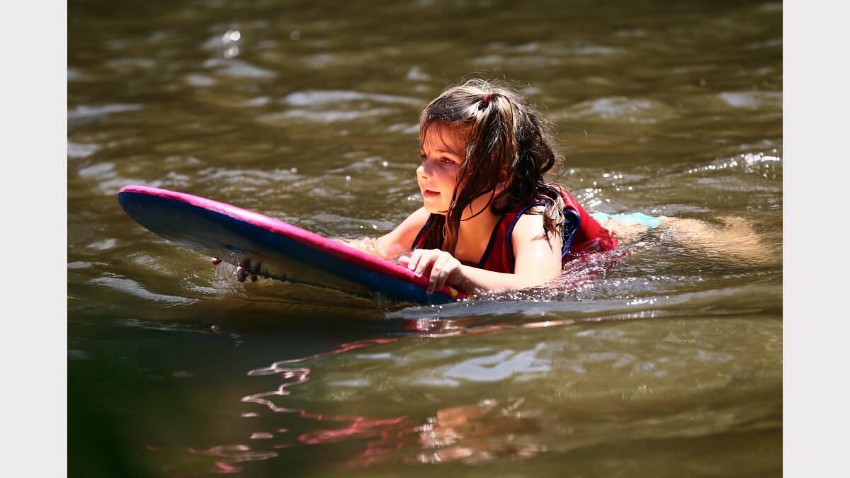  Alicia Turner, 5, surfs on her body board. 