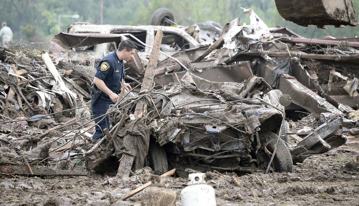 A rescuer searches the wreckage of a car after a tornado struck Moore, Oklahoma, May 20, 2013. Photo: REUTERS/Gene Blevins