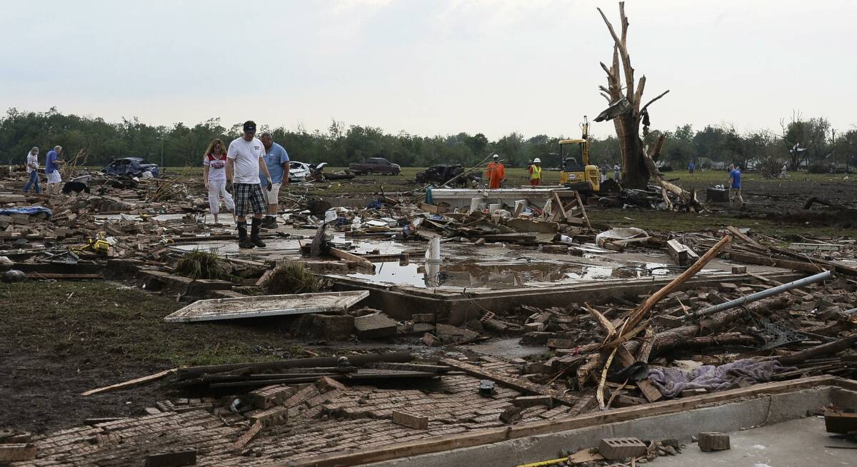 People look through the wreckage of their neighborhood after a tornado struck Moore, Oklahoma, May 20, 2013. Photo: REUTERS/Gene Blevins
