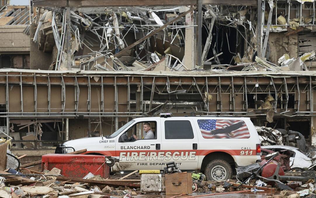 A fire official drives through the rubble of Moore Medical Center after a tornado struck Moore, Oklahoma, May 20, 2013. Photo: REUTERS/Gene Blevins