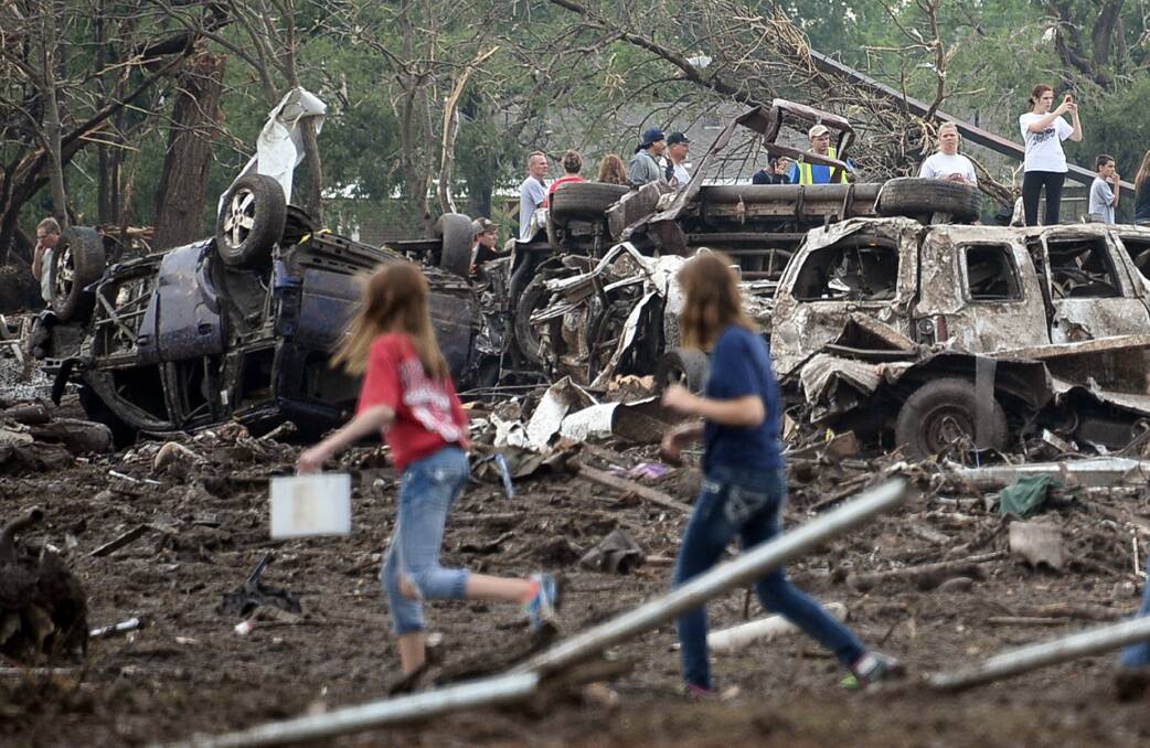 People look through the wreckage of their neighborhood after a tornado struck Moore, Oklahoma, May 20, 2013. Photo: REUTERS/Gene Blevins