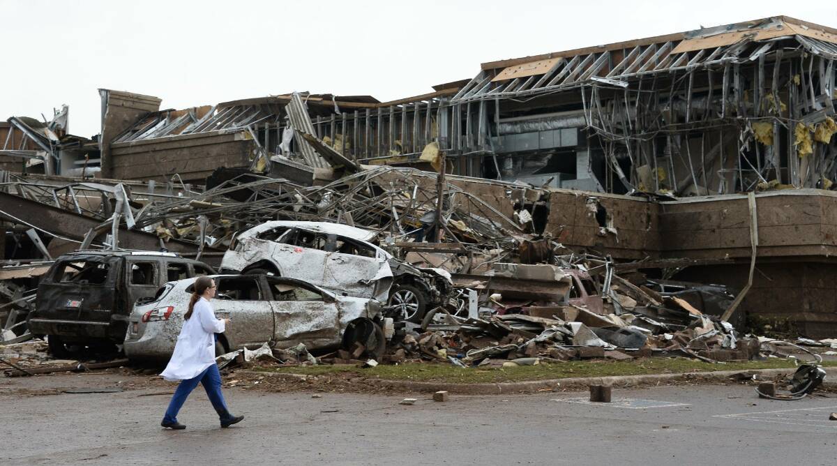 A nurse walks past the destruction at Moore hospital after a huge tornado struck Moore, Oklahoma, near Oklahoma City, May 20, 2013. Photo: REUTERS/Gene Blevins