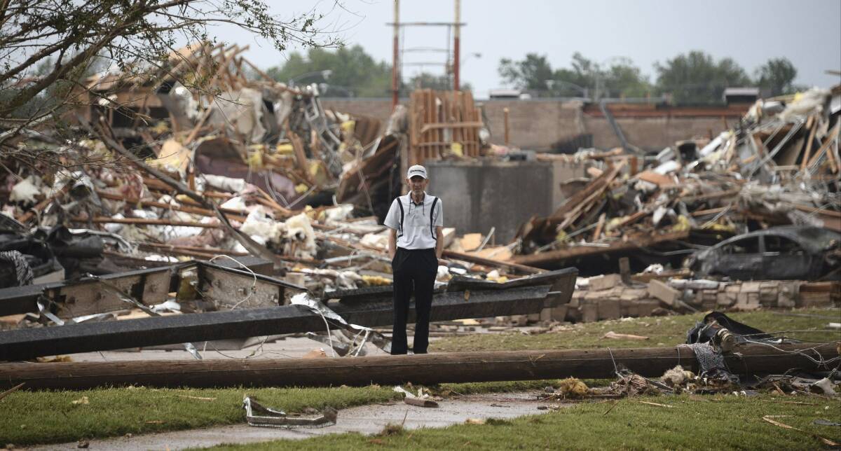 A man stands among the wreckage after a tornado struck Moore, Oklahoma, May 20, 2013. Photo: REUTERS/Gene Blevins