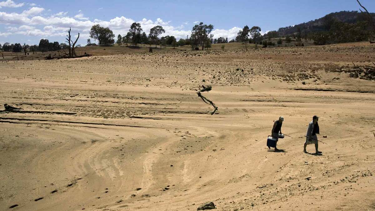 Fishermen walk up the dried banks of Lake Hume near Albury in November 2006. Picture: Nick Moir