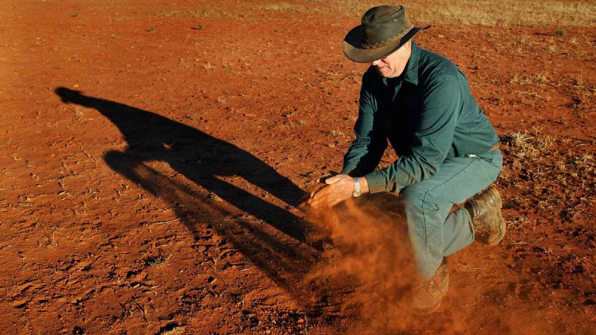 West Wyalong farmer Geoff West inspects a dry paddock in July 2005. Picture: Jim Rice