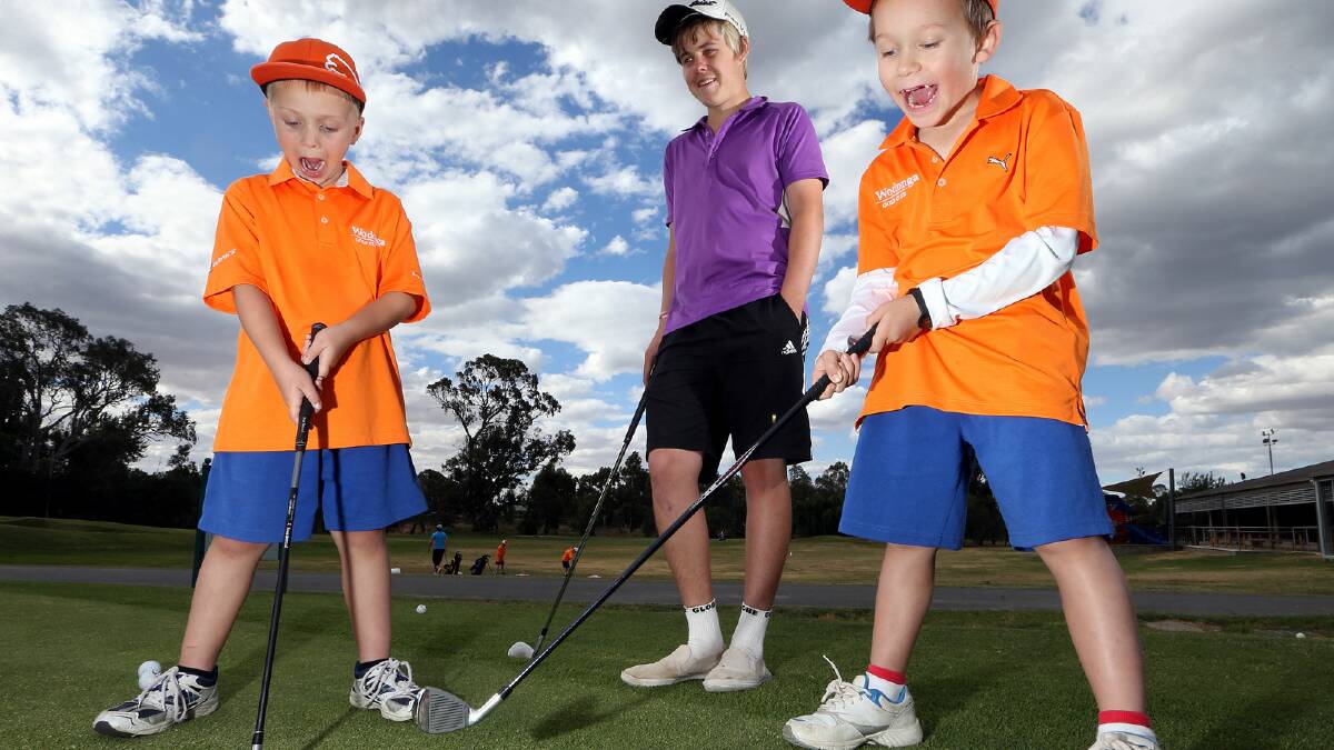 Golf instructor Jayden Walker gives a helping hand to Tyler Gutsche, 7, and Matthew Allen, 7, at Wodonga Country Club. It is Jayden’s way of giving back. Picture: KYLIE ESLER
